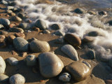 Water Washes up on Smooth Stones Lining a Beach