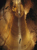 Cavers Cling to a Rope While Exploring the Cave