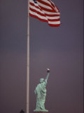 A Rear View of the Statue of Liberty and a Fluttering American Flag