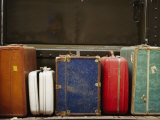 Colorful But Worn Luggage Awaits Travelers in a Train Station