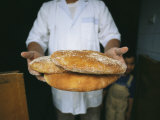A Baker Shows His Fresh Loaves in the Village Bakery
