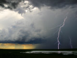 Lightning Cracks in a Cloud-Filled Sky with Rain Falling in Distance