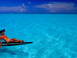 Woman Basking in the Sun on an Outrigger Boat in an Island Lagoon  Huahine Iti  French Polynesia