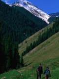 Trekkers Walk Between the Kol-Say Lakes with the Alatau Mountains Behind  Kazakhstan