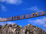 Hikers Crossing Steel Suspension Bridge Over Crevasse  Wolchulsan National Park  South Korea