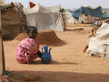 A Girl Washes Plates for Her Family in the North Darfur Refugee Camp of El Sallam October 4  2006