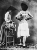 Lady Tries on a Corset While Another Woman Waits with Another One