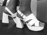 Close-Up Photograph of Feet in a Pair of White Platform Sandals