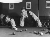 Snooker Player Prepares to Play a Shot as His Partner Looks On