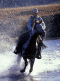 Cowboy on Horseback Galloping through River  Ponderosa Ranch  Seneca  Oregon  USA