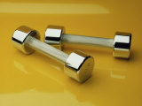 Hand Weights on a Reflective Yellow Surface