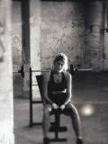 Young Woman Sitting on a Weight Bench