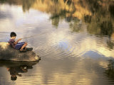 Boy Fishing from a Rock on a Pond
