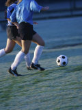 Two Teenage Girls Running for a Soccer Ball