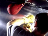 Rear View of a Boxer Punching a Punching Bag