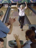 Senior Woman Raising Her Arms in Excitement at a Bowling Alley