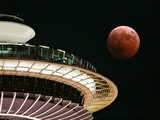 The Full Moon Turns Red and Orange as It Passes the Space Needle