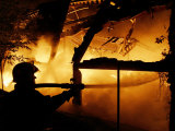 A Firefighter Tries to Extinguish a Raging Fire