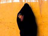 A Veiled Woman Carries Her Child Through the Streets of Erfoud