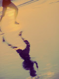 Reflection of a Young Man Running on the Beach