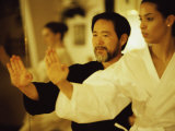 Mature Man Teaching a Young Woman Martial Arts
