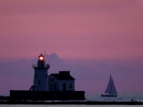 A Sailboat Slips Past a Lighthouse as the Sunset Comes to Lake Erie off the Coast of Cleveland