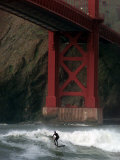 A Surfer is Dwarfed by the Northern End of the Golden Gate Bridge While Riding the Waves