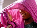 A Woman Shields Her Child from the Sun Using Her Scarf