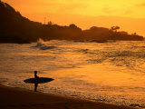 Surfer Standing at Waimea Bay at Sunset  Waimea  USA