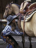 Female Wrangler Saddles Horse at Boulder River Ranch  Montana  USA