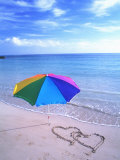 Umbrella on the Beach with Hearts Drawn in the Sand