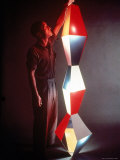 Japanese American Sculptor Isamu Noguchi Adjusting a Light Sculpture He Designed