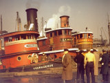 Men at pier looking at 3 Tugboats  One Named "Courageous" with Crewmen on Deck