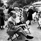 Vincente Minnelli with coffee sitting in chair with Daughter Liza at Outdoor Children's Party Being
