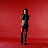 Rock Star Jim Morrison of the Doors Holding Microphone Alone as He Stands Against a Red Backdrop
