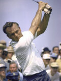 Golfer Arnold Palmer Swinging Club as Spectators Look on at Event