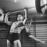 Weightlifter Charlie Morris at Southtown YMCA Working Out While Bob Byerwalter Works on Stall Bar