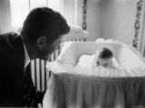 Sen Jack Kennedy Admiring Baby Caroline as She Lies in Her Crib in Nursery at Georgetown Home