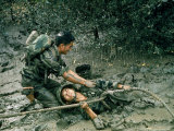 SVietnamese Soldier freeing friend after Ladder Bogged Down in Bottomless Mud During Vietnam War