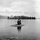 Young Couple Embracing on Small Rock Protruding from the Waters of Lake George