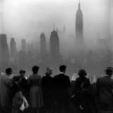 People on Top of a Building Looking Down Into Downtown Misty Smog covering Empire state Building