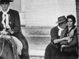 Man in Traditional Gaucho Attire Riding Horseback as Another Flirts with Woman During Creole Week