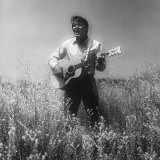 Singer Glen Campbell Playing and Posing in Field of Weeds