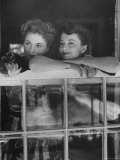 Actress Joan Fontaine with Actress Sister Olivia de Havilland Looking Out of Open Window at Home