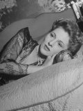Actress Joan Fontaine Wearing Sheer Negligee While Lounging on Bed at Home