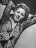 Actress Joan Fontaine Wearing Sheer Negligee While Lounging on Bed at Home