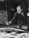Jackson Pollock Dribbling Sand on Painting While Working in His Studio