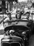 Teenage Boys and Girl  Riding in "Hopped Up" Convertible Car Along Palm Tree Lined Street