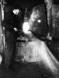 Glass Blower Heating Up Molten Glass Prior to Blowing a Glass Piece at Corning Glass Plant