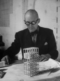 Architect Le Corbusier Studying Architectural Plans and Small Model of Building in His Office